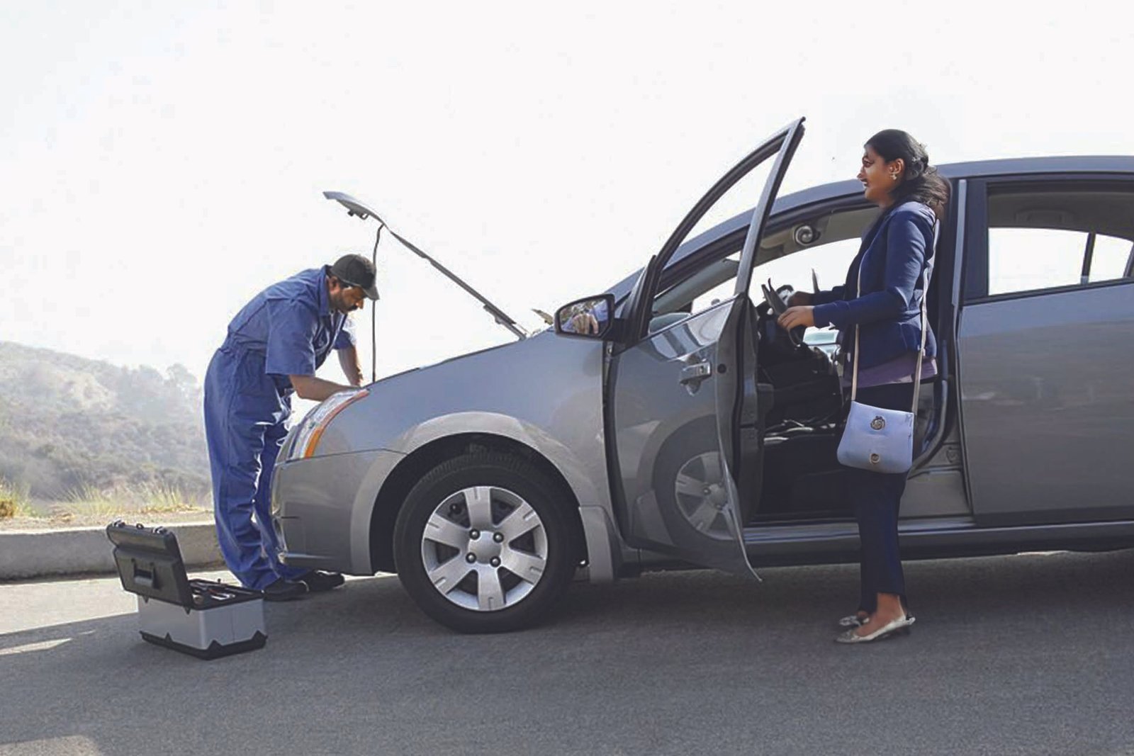 Mechanic repairing a car engine on the roadside