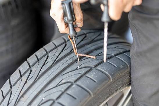 Mechanic repairing a flat tyre on the roadside