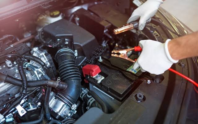 Mechanic jumpstarting a car battery